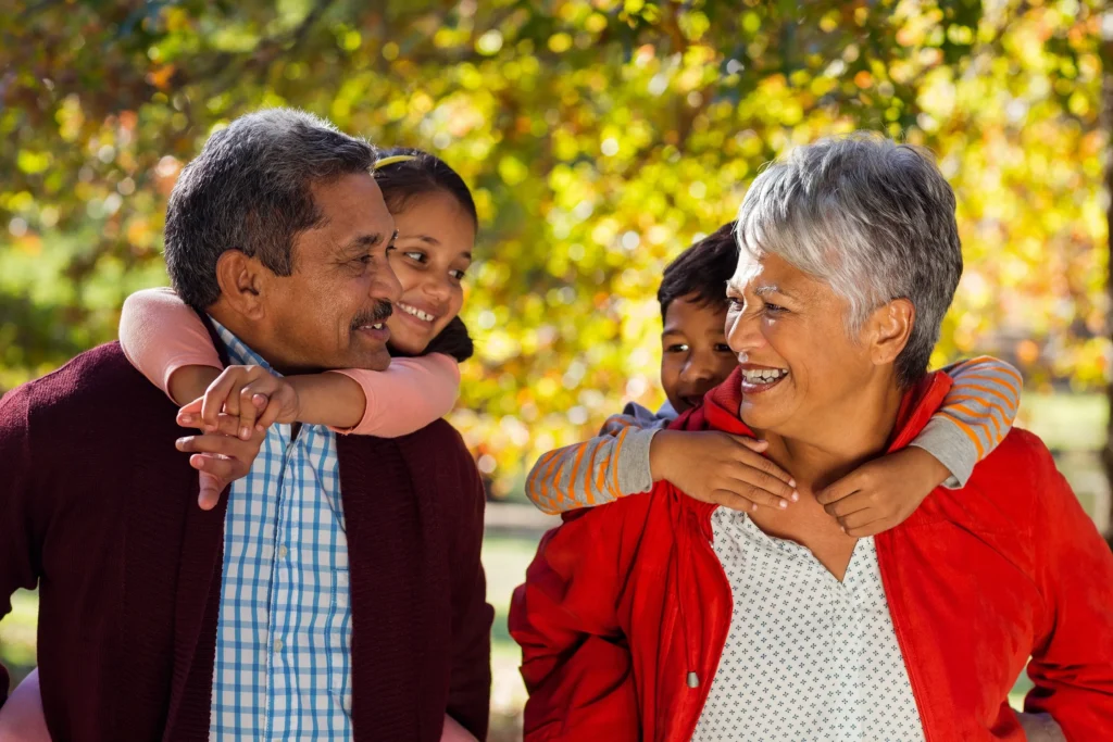 Two grandparents walking with their grand kids.